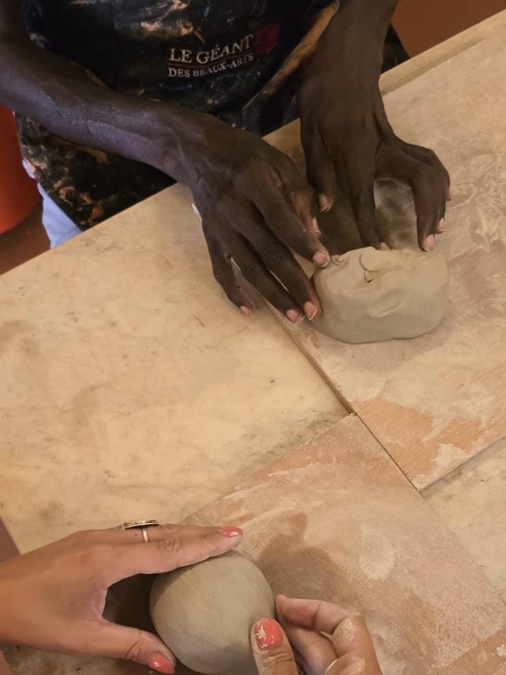 Deux paires de mains façonnant des boules d'argile